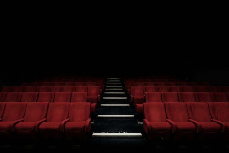 Sala de cine con butacas iluminadas para proyección audiovisual incluyente con audiodescripción y subtítulos